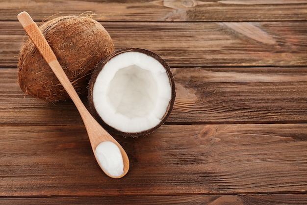 Cuchara con aceite de coco en mesa de madera