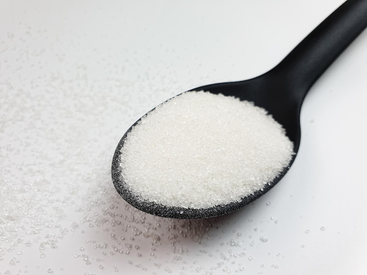 Foto cuchara de azúcar ingrediente aditivo de azúcar sobre fondo blanco