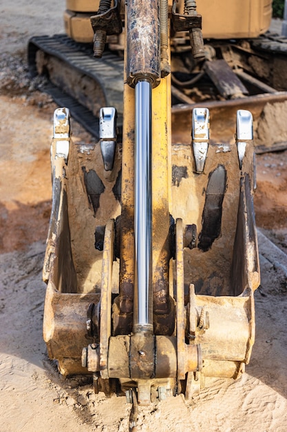 Foto cuchara de excavadora de cerca. trabajos de excavación en obra y construcción de carreteras. maquinaria de construcción.