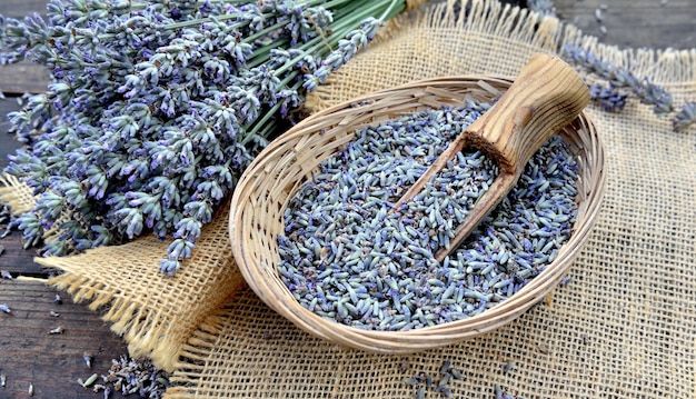 Cuchara de madera en una cestita llena de pétalos de flores de lavanda sobre una mesa de maderax9