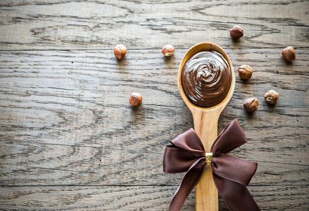 Cuchara de madera con crema de chocolate y avellanas.