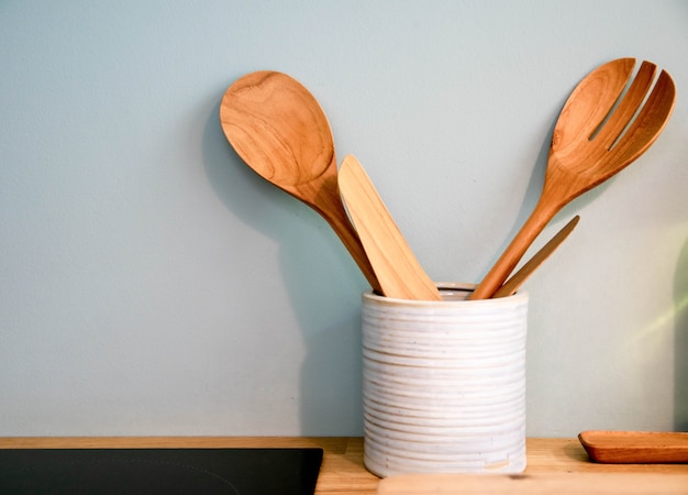 Foto cuchara de madera y gente de madera en la cocina.