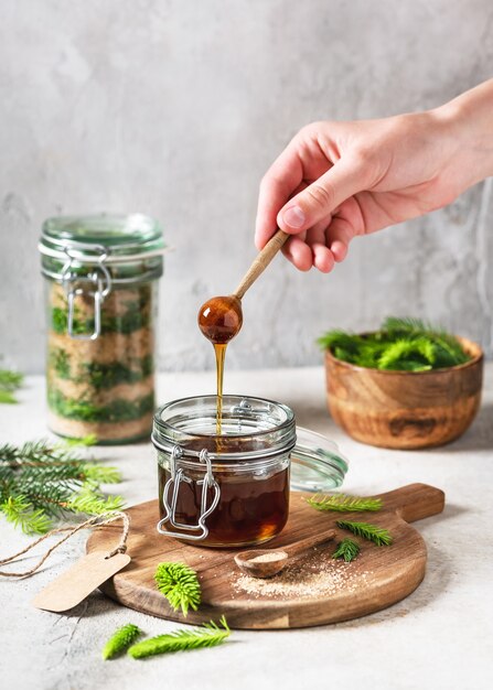 Foto cuchara de madera con miel casera que fluye hecha de puntas de abeto verde joven y azúcar natural