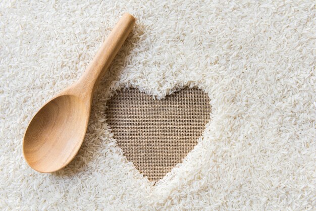 cuchara de madera sobre fondo de arroz Espacio en medio de un corazón. cilicio es fondo