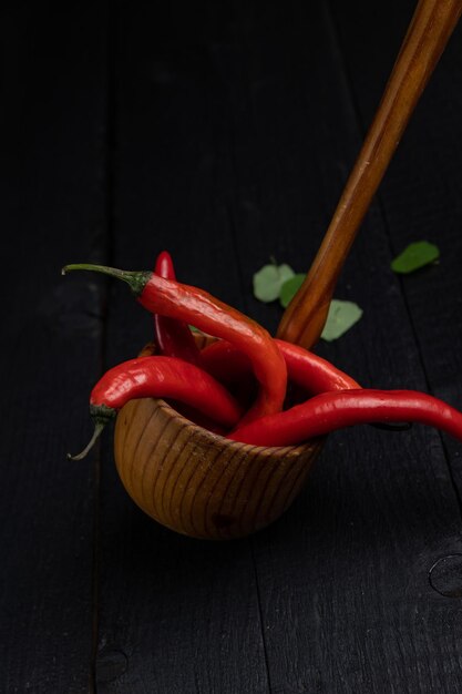 Cuchara de madera sobre un fondo oscuro con verduras