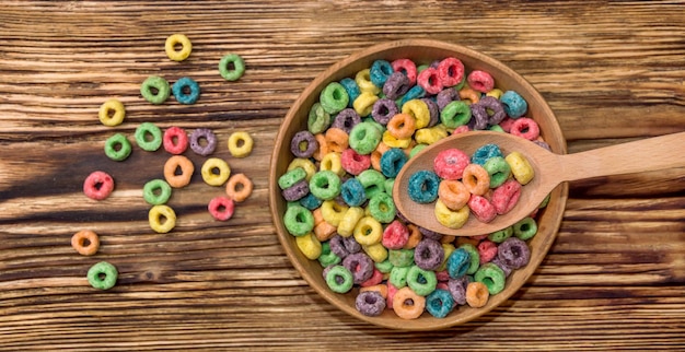 Cuchara de madera y tazón de madera con cereal colorido