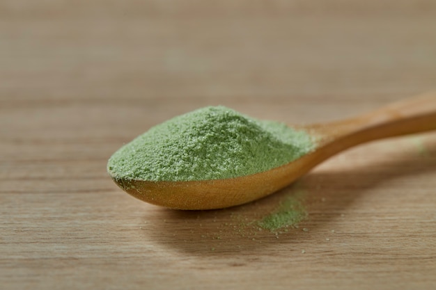 Cuchara de madera con té verde matcha en polvo.