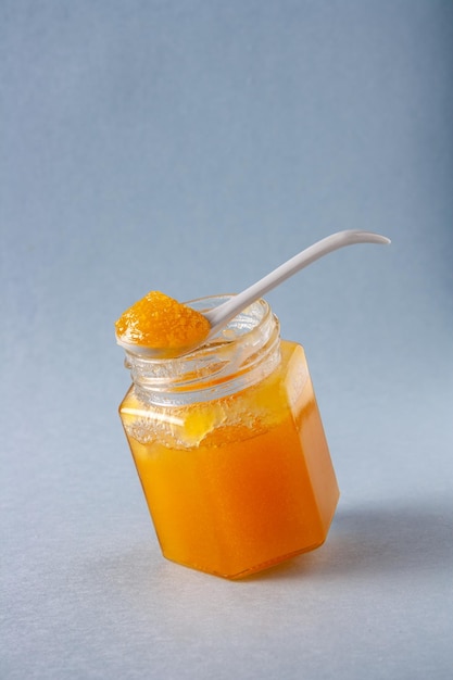 Una cuchara con miel se encuentra en un espacio de copia de tarro