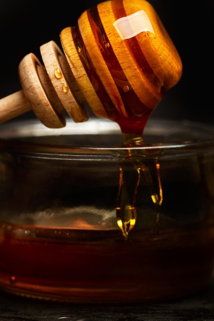 Foto cuchara de miel con miel en un frasco en una vista de cerca