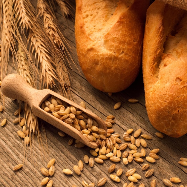 Cuchara con pan de grano y panes en el escritorio de madera