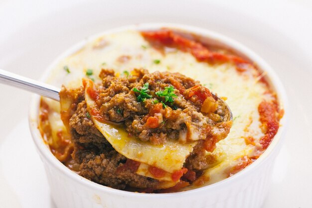 una cuchara que muestra algo de carne de res rellena en lasaña