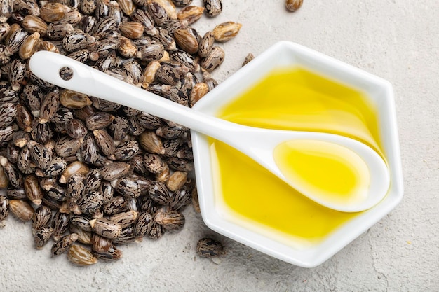 Cuchara de semillas de aceite de ricino y vista superior del tazón blanco