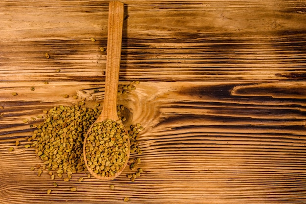 Cuchara con semillas de fenogreco en la mesa de madera Vista superior