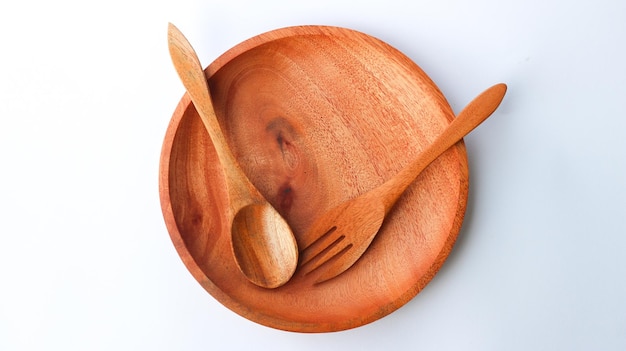 Cuchara y tenedor de madera en un plato