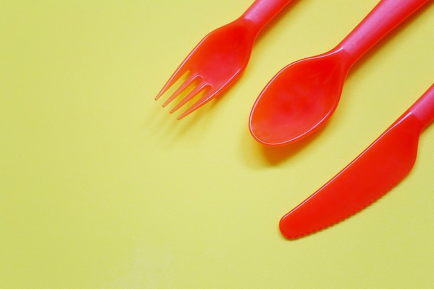 Foto cuchara y tenedor de plástico colocados sobre un