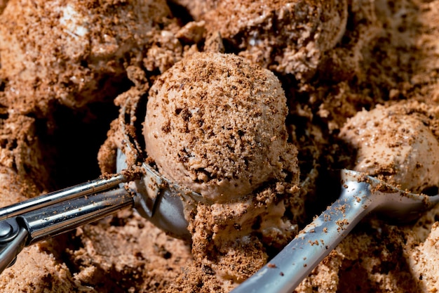 Una cucharada de helado de chocolate con dos cucharas.