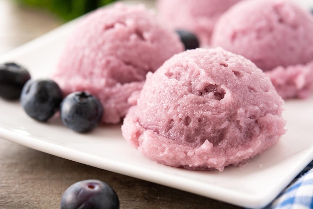 Cucharadas de helado de arándanos en la mesa de madera