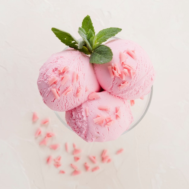 Foto cucharadas de helado rosa en un tazón de vidrio