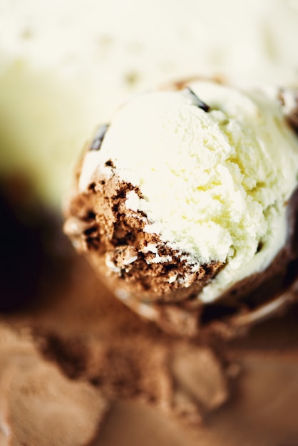 Cucharadas de vainilla y helado de chocolate. Postre de yogur dulce o textura de helado marrón.