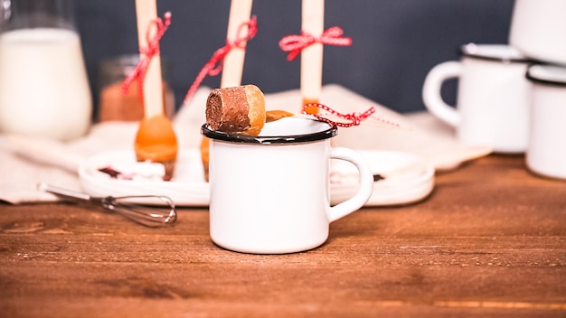 Cucharas de cacao caliente con caramelo salado en taza de metal.