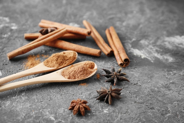 Cucharas con canela en polvo sobre fondo gris