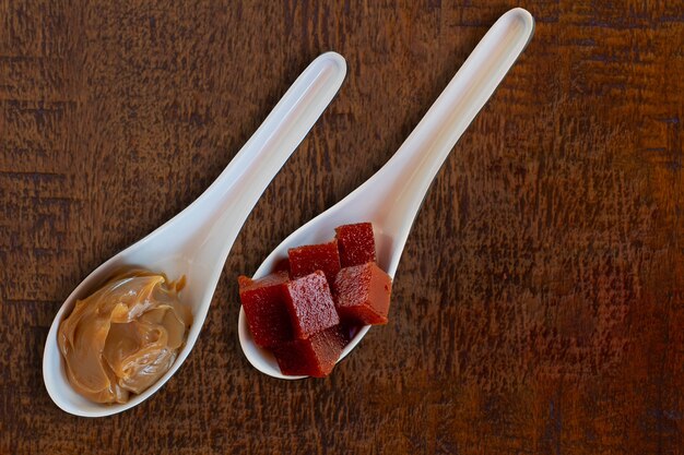 Cucharas con dulce de leche y guayaba sobre mesa de madera Postres brasileños