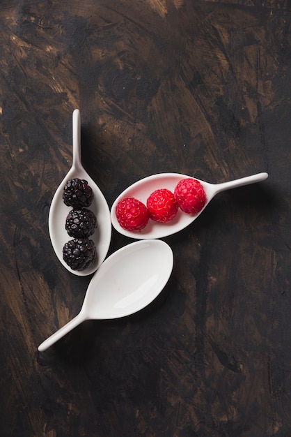 Cucharas con fondo de frambuesa y moras negras.