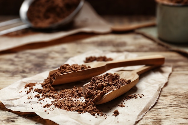 Cucharas de madera con cacao en polvo sobre servilleta de papel