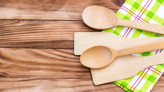 Cucharas de madera y pala de madera con toalla de cocina sobre la mesa Vista superior Espacio de copia