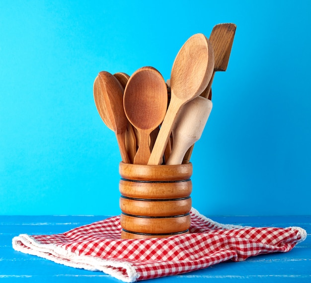 Cucharas de madera en un recipiente de madera en mesa azul