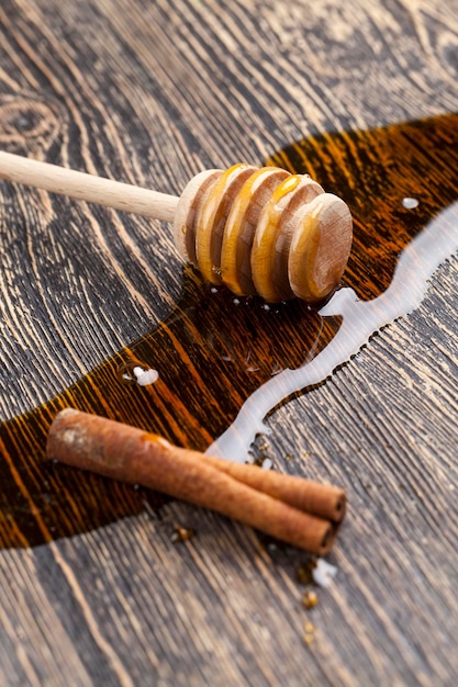 Cucharas de miel y miel en una mesa de madera