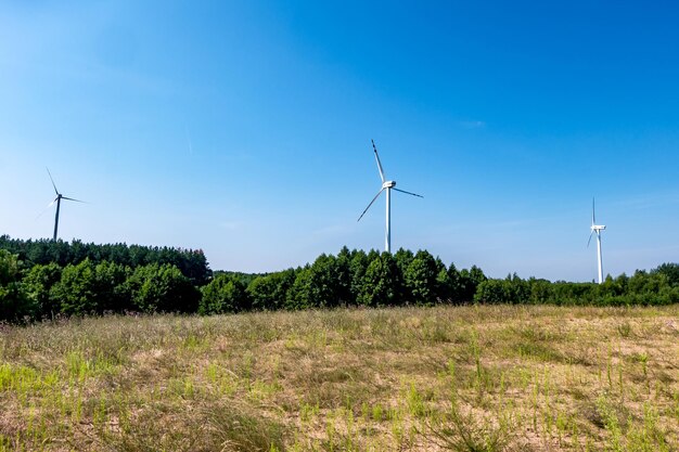 Cuchillas giratorias de una hélice de molino de viento sobre fondo de cielo azul Generación de energía eólica Energía verde pura