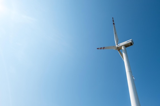 Cuchillas giratorias de una hélice de molino de viento sobre fondo de cielo azul Generación de energía eólica Energía verde pura