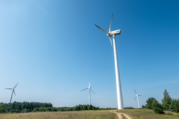 Cuchillas giratorias de una hélice de molino de viento sobre fondo de cielo azul Generación de energía eólica Energía verde pura