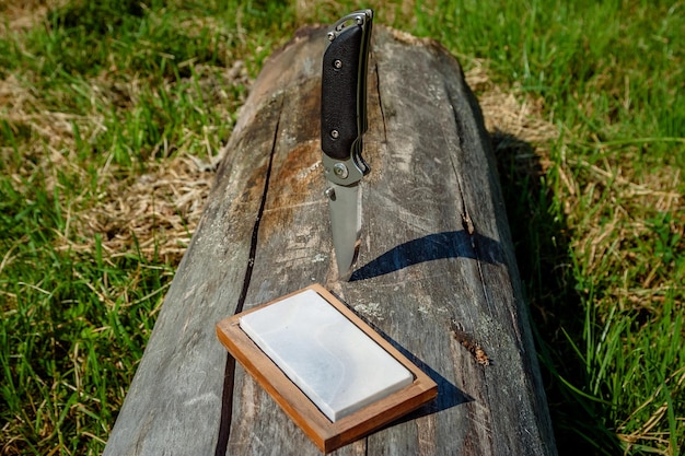 Cuchillo afilado y muela sobre un fondo de madera