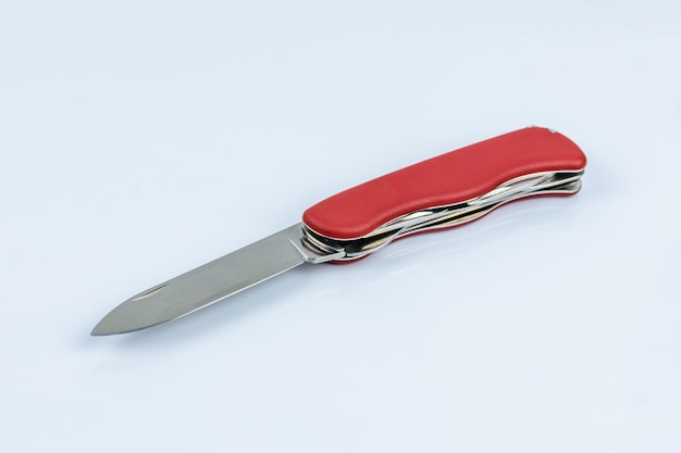 Cuchillo de bolsillo rojo multiusos desplegado aislado en un fondo blanco