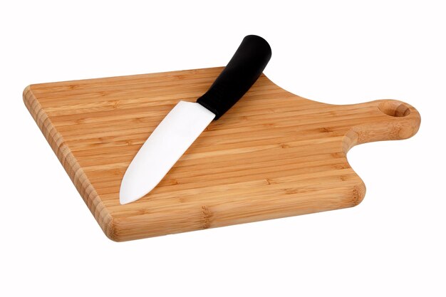 Cuchillo de cerámica en placa de cocina sobre fondo blanco.