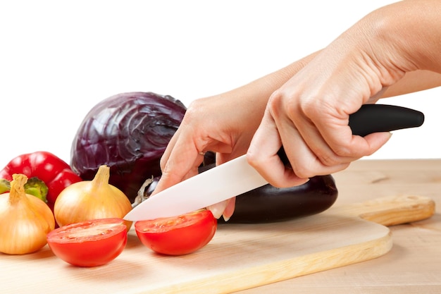 Cuchillo de cerámica con verduras en placa de corte