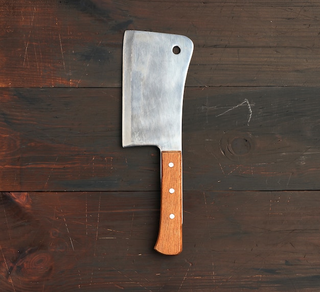 Cuchillo de cocina grande para cortar carne y verduras en un espacio de madera marrón