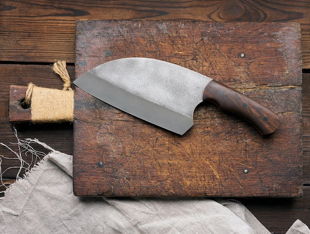 Cuchillo de cocina grande en una vista superior de tabla de cortar de madera vacía