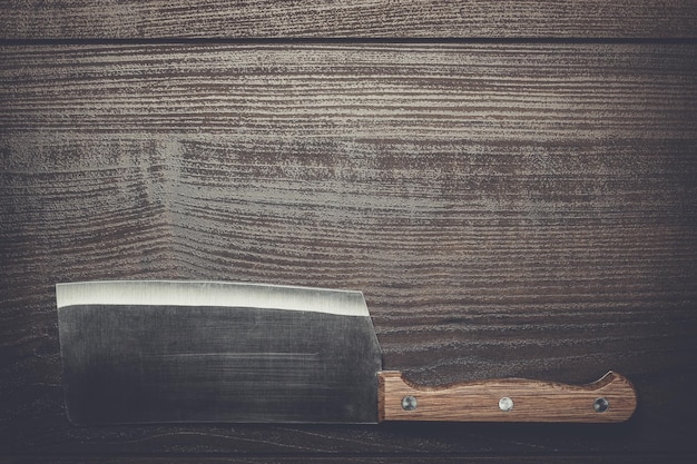 Cuchillo de cocina en mesa de madera marrón