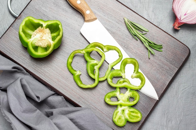 Cuchillo de cocina y pimiento verde picado en tabla de cortar