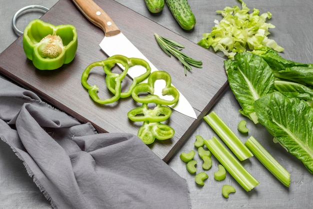 Cuchillo de cocina de pimiento verde picado y en tabla de cortar