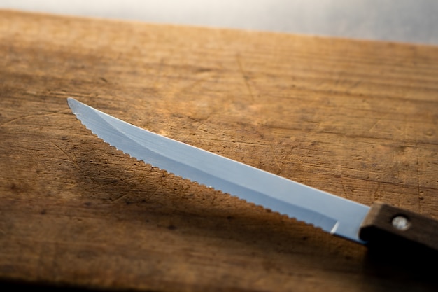 Foto cuchillo de cocina sobre una tabla de madera.