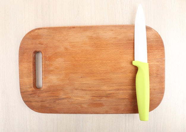 Cuchillo de cocina y tabla de cortar en una mesa de madera