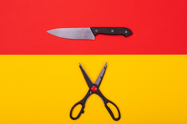 Cuchillo de cocina y tijeras se encuentran aisladas un amarillo-rojo