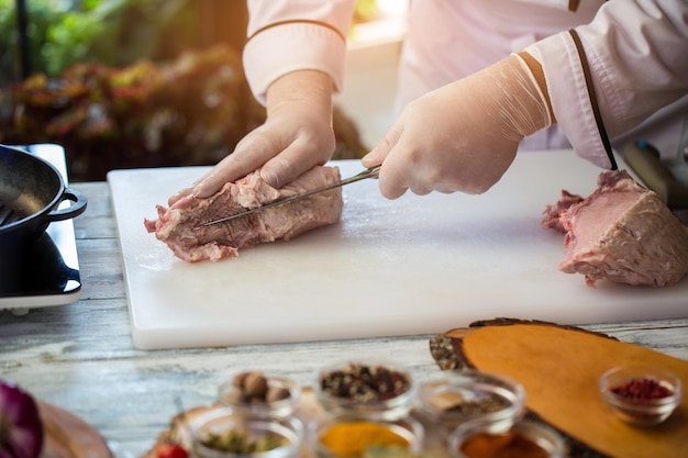 El cuchillo está cortando carne cruda.