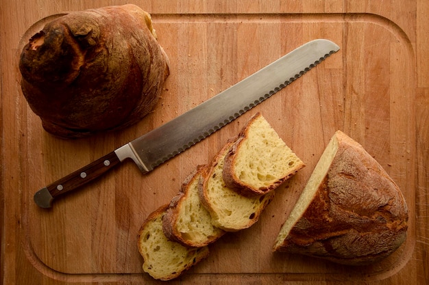 Un cuchillo junto a una hogaza de pan en una tabla para cortar