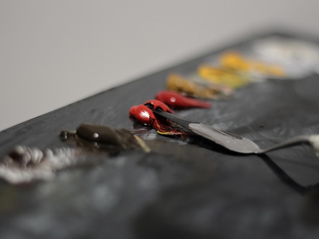 Foto un cuchillo con mangos rojos está sobre una mesa con otros artículos.