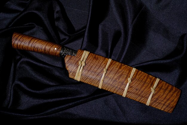 Cuchillo personalizado o Enep en la vaina de madera natural sobre fondo de mesa antiguo hecho a mano de Tailandia